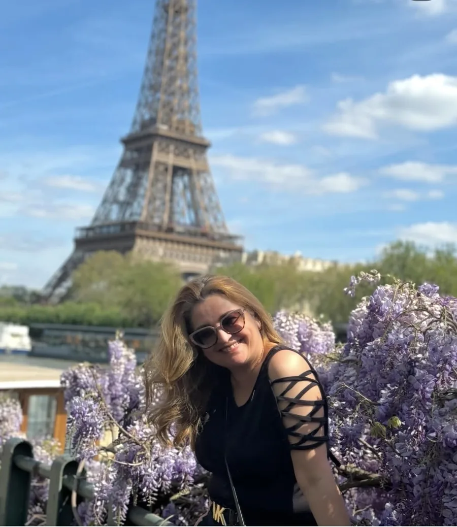 Moema Rodriguez em frente à Torre Eiffel, entre glicínias floridas